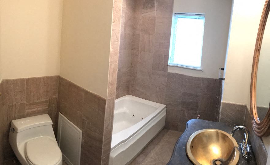 a bathroom with a toilet and a tub and a sink